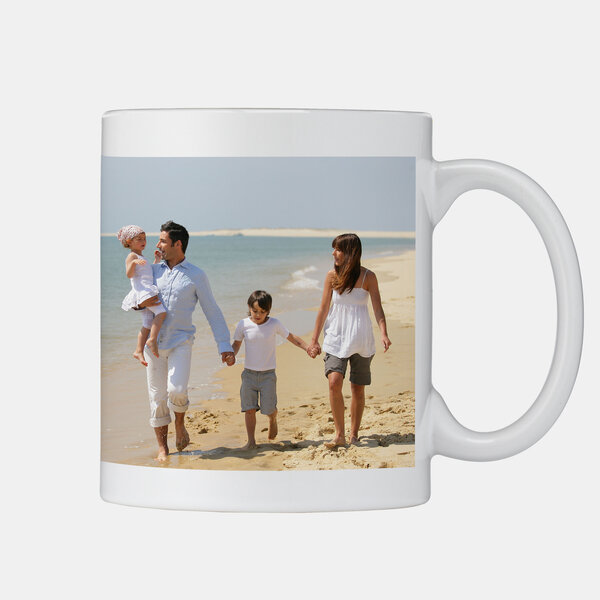 Die personalisierte Fototasse zeigt eine Familie mit zwei Kindern beim Spaziergang am Strand an einem sonnigen Sommertag.