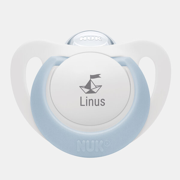 Der blaue NUK Schnuller STAR in Größe 1 für Babys von 0 bis 6 Monate zeigt ein Papierboot mit Fähnchen und den Namen Linus.